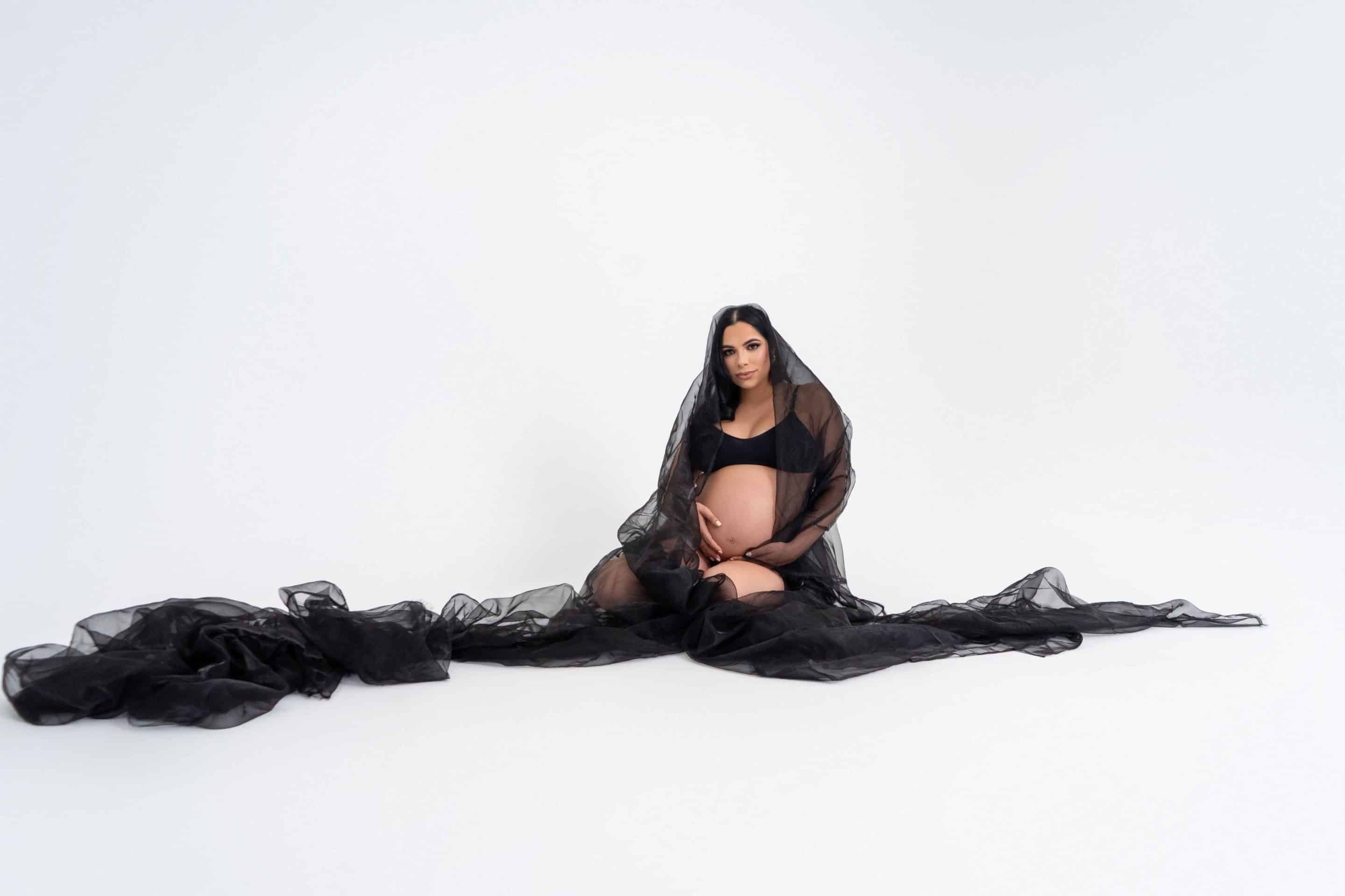 Model in black posing on the studio floor during a fashion shoot at a Miami photo studio