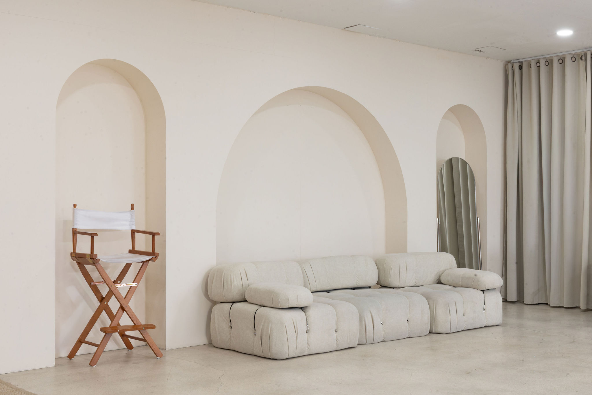 Styled prop set with a directors chair beside the arch wall in a Miami photo studio